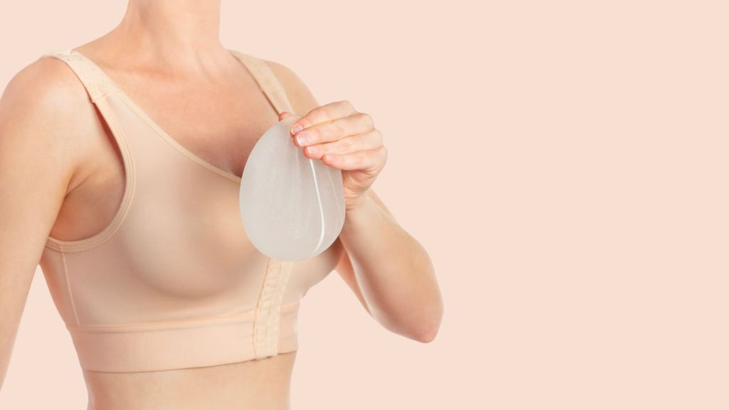 woman holding a silicon for breasts